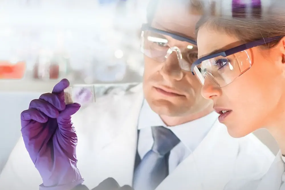 Muškarac i žena promatraju uzorak u laboratoriju