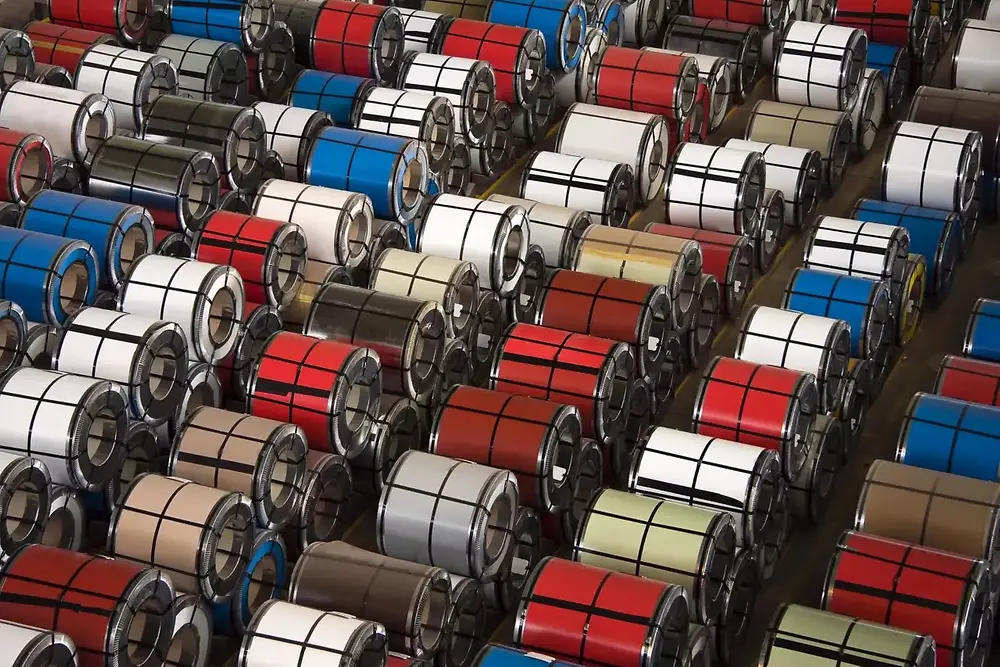 Krupni plan složenih metalnih zavojnica u industrijskom skladištu.