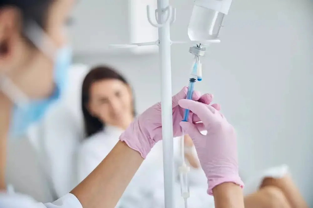 Medicinski djelatnik drži infuzijsku vrećicu u zdravstvenom okruženju.