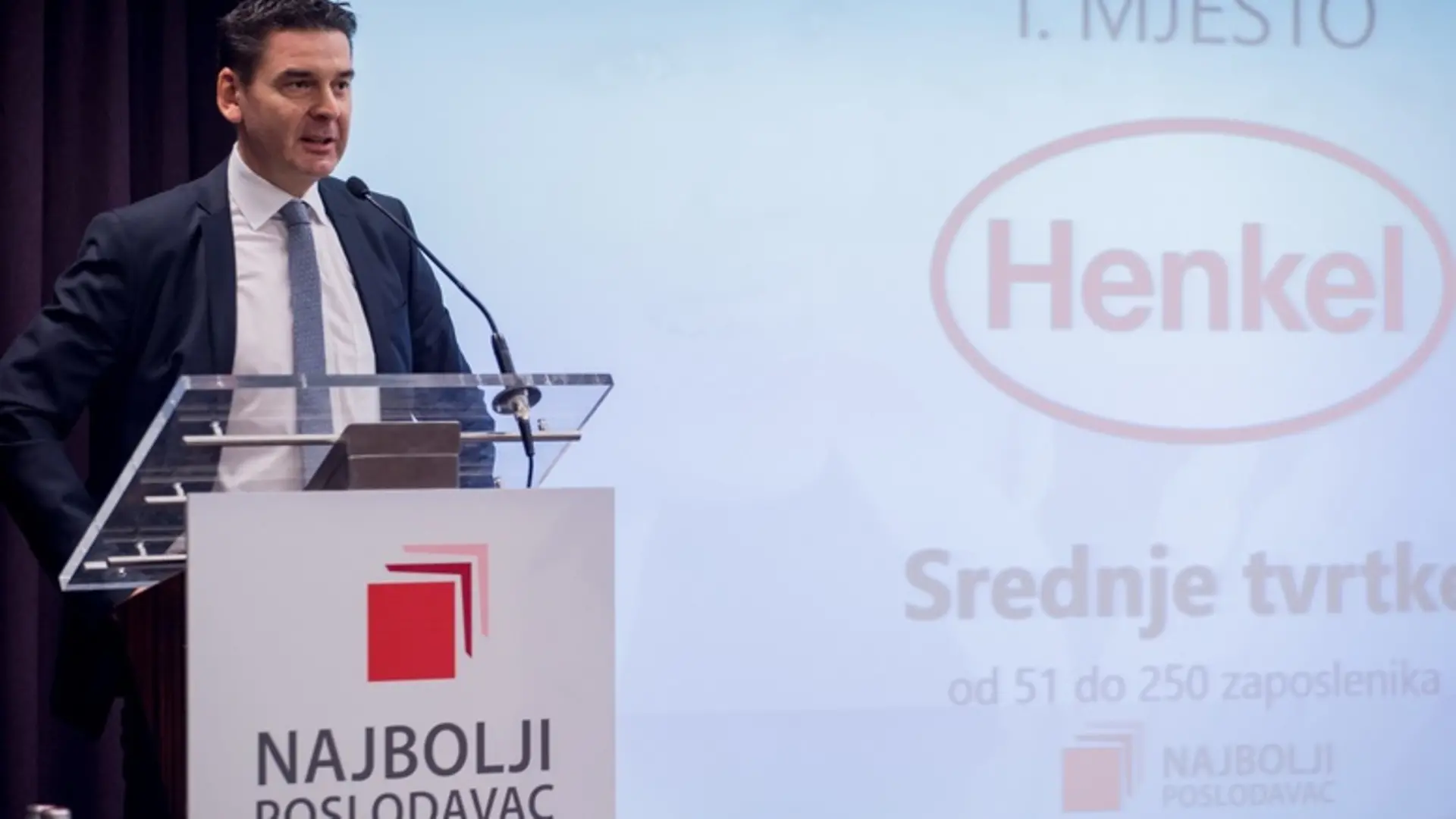 Nagradu preuzeo Mario Altan, tadašnji član uprave Henkel Adria, u pozadini na zaslonu piše: „1. mjesto Henkel Srednje tvrtke od 51 do 250 zaposlenika”, a na dnu zaslona nalazi se logotip „Najbolji poslodavac”.